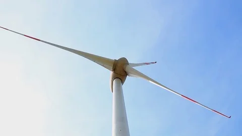 Close up of rotating wind turbine propeller blades in the blue sky Stock Footage 75545712