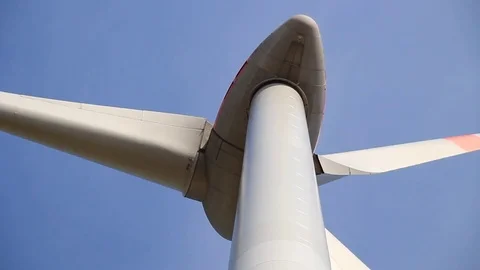 Close up of rotating wind turbine propeller blades in the blue sky Stock Footage 75545982
