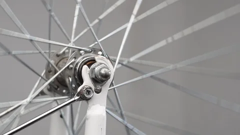 Close-up rotation of the front wheel of a bicycle, front hub with spokes on a Stock Footage 115125869