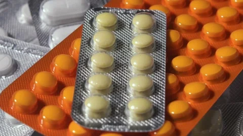 Close-up rotation shows assorted pills in blister packs, highlighting medication Stock Footage 327451819