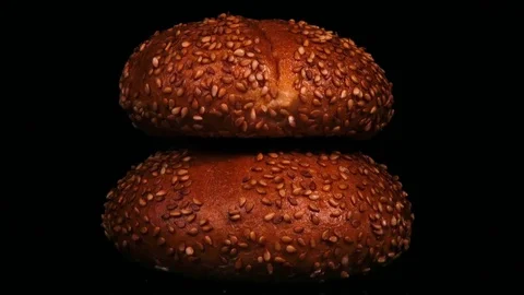 Close up rotation of two fresh baked stacked sesame buns on black background. 4K Видео 73901777