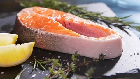 Close up rotation view of seasoning process of salmon’s fillet. Spicing with Stock Footage 107379818