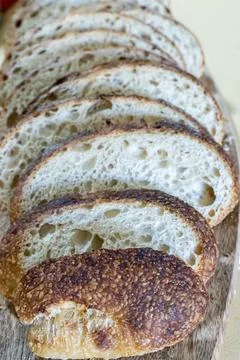Close-up of rough and grain-like crust of freshly sliced white bread Фото
