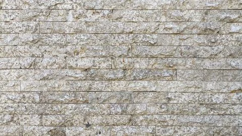 Close-up of rough beige stone brick wall texture with natural patterns and .. Stock Photos