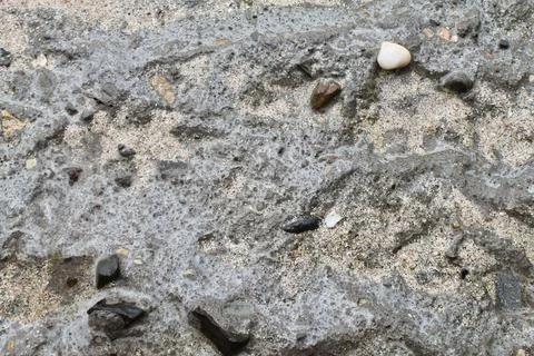Close-Up of Rough Concrete Ground Covered with Sand and Small Stone Fragments Fotos de archivo