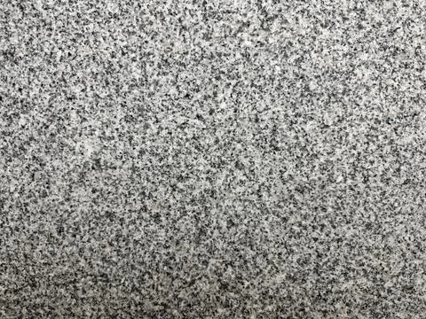 Close-up of rough gray granite stone surface with natural speckled texture. Stock Photos