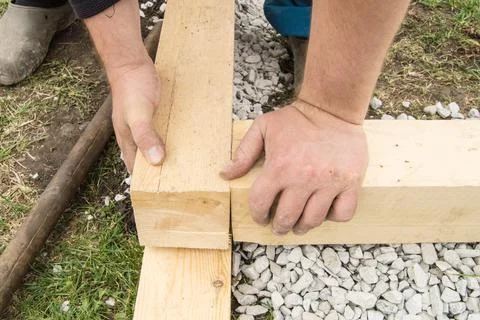 Close-up of rough male hands using new lumber for work, outdoors Stock-Fotos