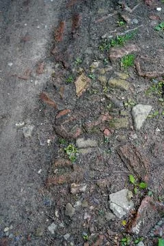 Close up of a rough road made of bricks and rubble Stock Photos