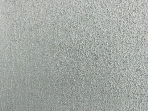 Close-up of a roughly textured, solid light grey wall surface under bright,.. 库存照片