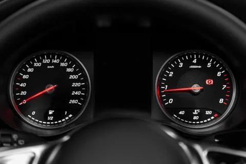 Close-up of round dashboard, speedometer and tachometer with white backlight. Stock Photos