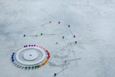 Close-up of a round holder of a set of sewing basting pins with colored heads Stock Photos