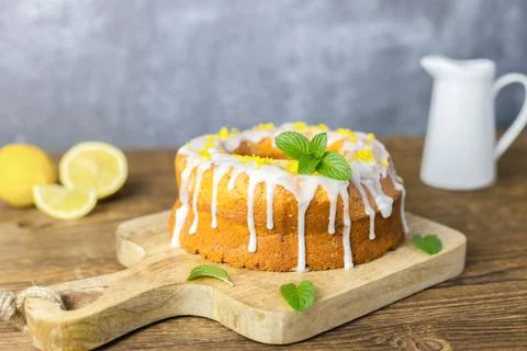 Close-up of a round lemon pie on a cutting board, decorated with frosting Stock Photos