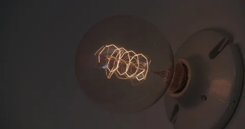 Close up Round Light Bulb Filament Turning On 1 - 60p Stock Footage 93753441
