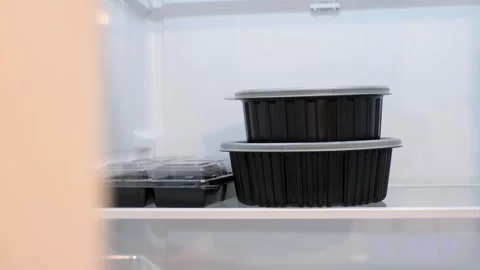 Close-up of round plastic boxes with lids containing food on shelf in a Stock Footage 325174414