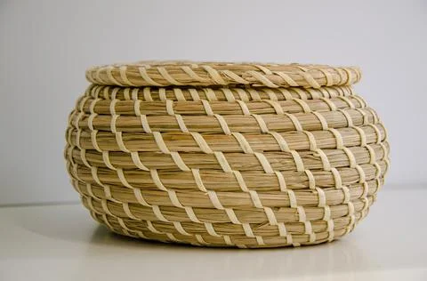 Close-up of round straw box with lid on white shelf. Eco-friendly items Stock Photos