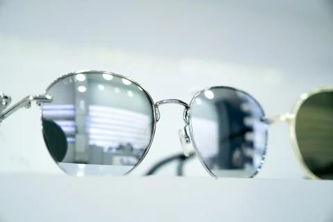 Close-up of round sunglasses with reflective silver lenses, highlighting stylish Stock Photos
