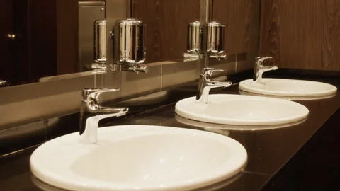 Close-Up of Row of Clean Ceramic Sinks Reflecting in Public Restroom Mirror Stock Footage 343791405