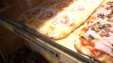 Close-up of a row of flatbread pizzas in the showcase table in front of the r Stock Footage 129928019