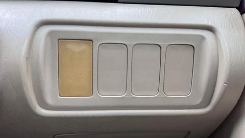 A close up of a row of four rounded rectangular switches on a light gray car Stock Photos