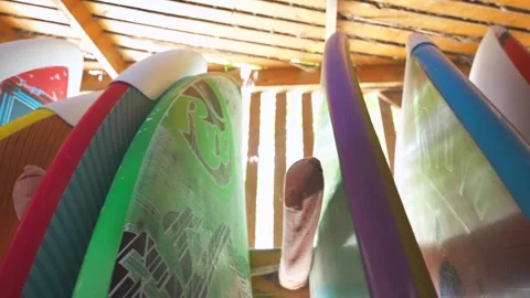 Close up of row of multicolored surfboards standing in the shadow on a board Stock Footage 252086765