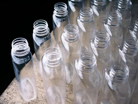Close up Row of plastic drink water bottlesfor filling process. Stock Photos