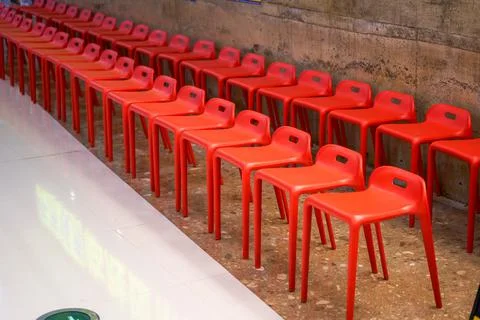 Close-up of a row of red high stools indoors Foto stock