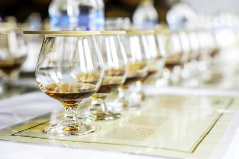 Close up of row transparent covered drinking glasses with rum on the tasting 스톡 사진