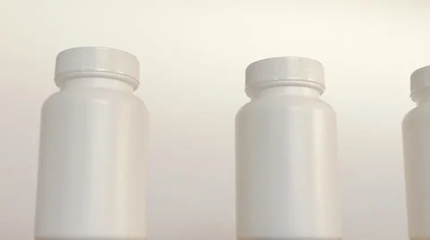 Close up of row of white bottles on conveyor belt Stockbeeldmateriaal 45344808