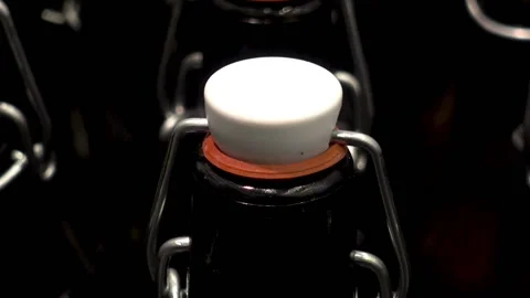 Close up of rows of dark glass bottles with lids. Stock Footage 86676307