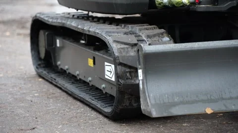 Close up of rubber crawler track and metal blade on construction machine show Stock Footage 320804025