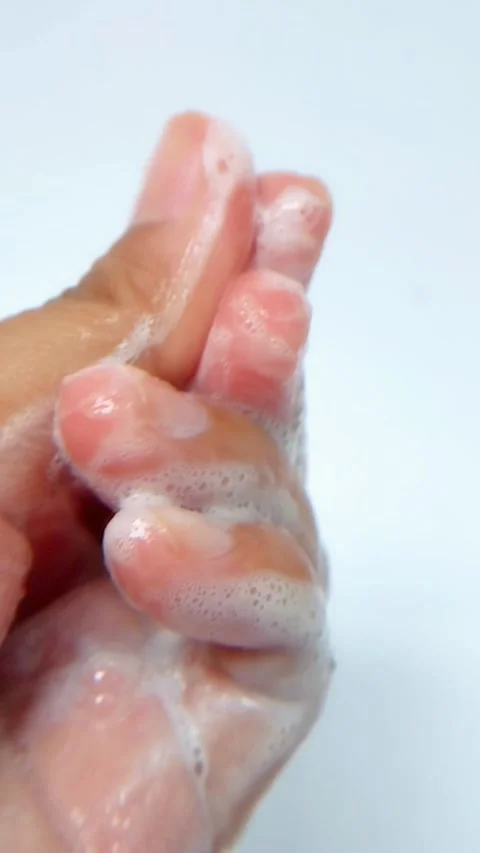 Close up of rubbing and spreading white foam on palm of hand. Detailed view.. Vídeo Stock 335022650