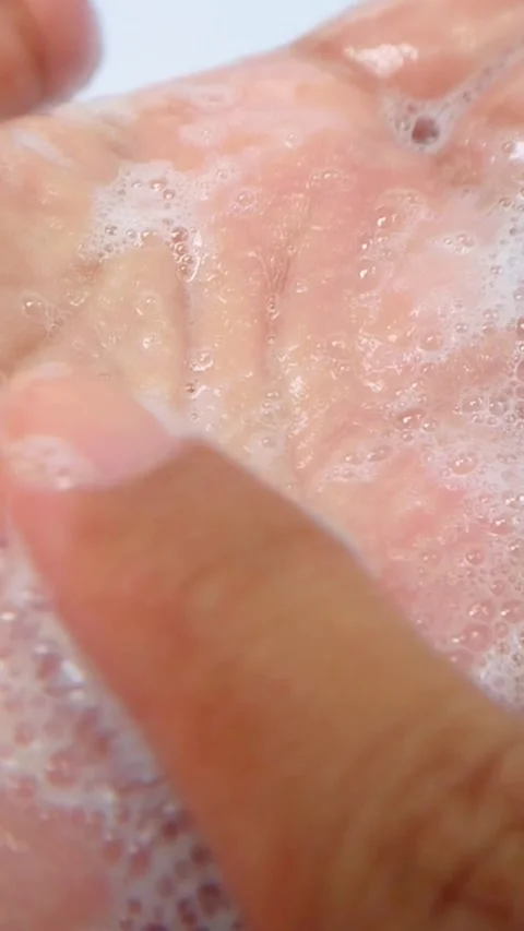 Close up of rubbing white foam on palm of hand using index finger. Detailed.. Vídeo Stock 335022670