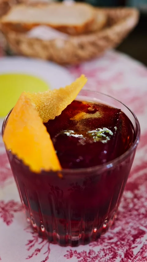Close up of ruby red negroni cocktail with large ice cube and orange peel g.. Stock Footage 339652302