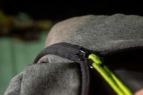Close up of a rugged gray backpack with green zipper cord, showcasing durab.. Stock-Fotos