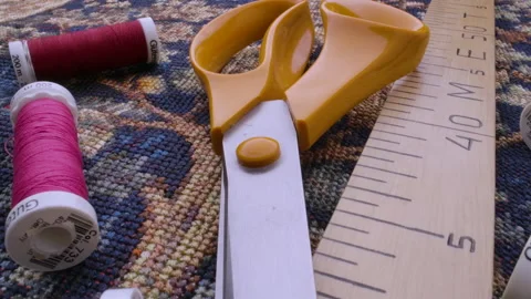 A close-up of a ruler, scissors and coils of thread of different colors Stock Footage 166903146