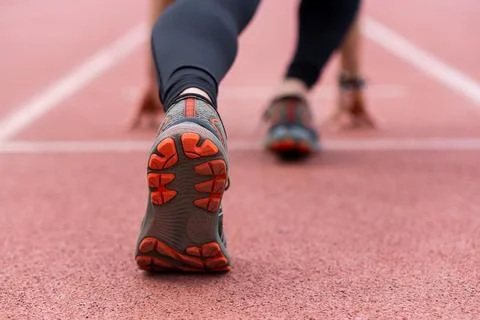 Close-up of runner legs in low start position, prepared to race along urban Stock Photos
