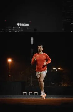 Close up of a runner running towards the camera at night 库存照片