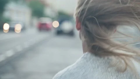 Close-up running after a girl with developing hair on the background of the road Stock Footage 217395323