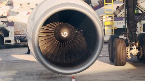 Close up of a running aircraft engine with ground crews and staff working Vidéo 107037362