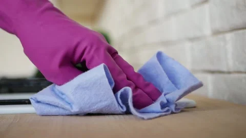Close up running with a hand in a rubber glove with a rag cleaning gas stove. Video stock 130845563