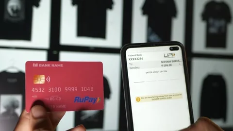 Close-up of RuPay card and smartphone as user initiates UPI payment Stock Footage 311502003
