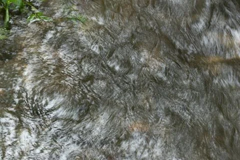 Close-up of Rushing Water Surface in a Fast-Flowing Stream Foto stock