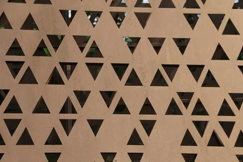 Close up of rust colored perforated metal panel with repeating triangular c.. Stock Photos