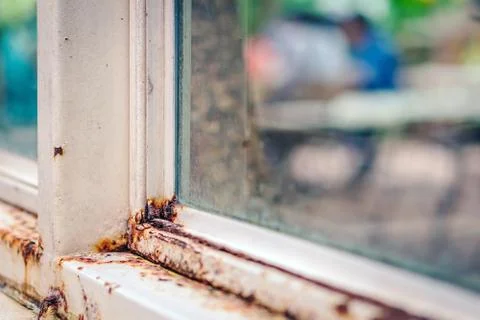 Close up of rust on an old white iron window in the corner of the frame with  Stock Photos
