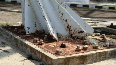 A close-up of a rusted metal structure base with bolts and nuts, showcasing.. Foto stock