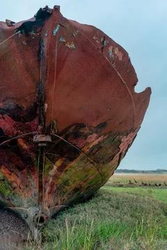 Close-up of rusted ship bow with peeling paint and algae on salt marsh Stock Photos