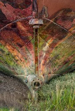 Close-up of rusted ship bow with peeling paint and algae on salt marsh Stock Photos