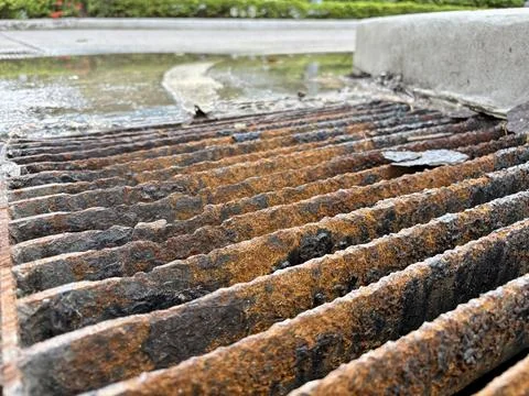 Close-Up of Rusted Storm Drain Grate with Water Runoff Stock Photos