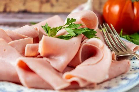 Close-up of a rustic arrangement of an exquisite ham on a old plate with a fo Stock Photos