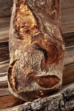 Close up of a rustic bread on wood logs Stock Photos